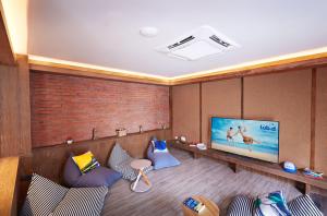 sala de estar con 2 sillas y TV de pantalla plana en Lub d Phuket Patong en Patong
