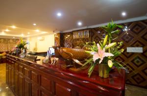 eine Lobby mit einer Bar mit Blumen darauf in der Unterkunft Good Luck Day Hotel & Apartment in Phnom Penh