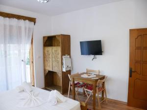 a bedroom with a bed and a table and a tv at Villa Marie 23 in Gjirokastër