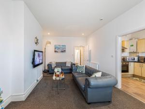 a living room with a couch and a table at Sea Shore Flat in Llandudno