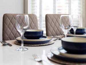 a table with plates and wine glasses on it at Sea Shore Flat in Llandudno