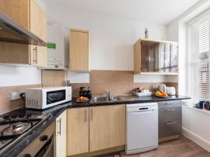 a kitchen with a sink and a microwave at Sea Shore Flat in Llandudno