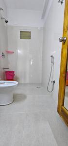 Un baño blanco con inodoro y ducha. en Om Homestay, en Tirupati