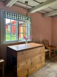 a kitchen with a wooden island with a vase of flowers at Historic Vicarage With Wood-Burning Stove in Eskilstuna