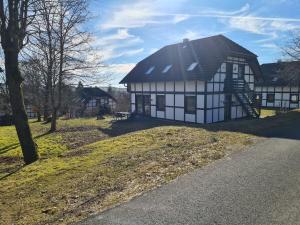 a white and black house with a black roof at Wohnung in Frankenau nahe Skipisten in Frankenau +30 photos