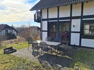 a patio with a table and chairs in front of a house at Wohnung in Frankenau nahe Skipisten in Frankenau