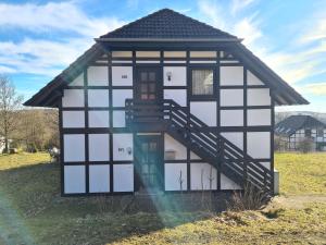 a small house with a staircase in a field at Wohnung in Frankenau nahe Skipisten in Frankenau