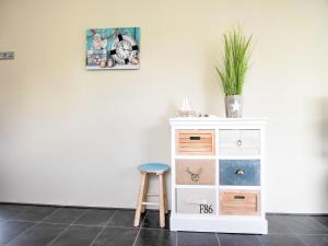 a stool next to a white dresser with a picture on the wall at Water Villa in Ooltgensplaat near Volkerak in Ooltgensplaat