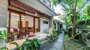a house with a porch with a bench and a table at Bendito Ubud in Ubud