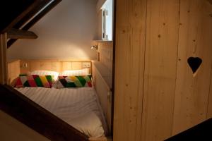 um quarto com uma cama numa parede de madeira em Ruyge Weyde Logies, Eco Farm em Oudewater