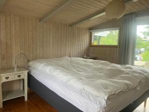 a large bed in a room with a window at Holiday Home With Panoramic View Of Kalø Bay in Knebel