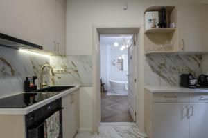 a kitchen with white counters and a sink and a tub at Eden Central Boutique Suites - Garden & Spacious Apartments in Cluj-Napoca +104 photos