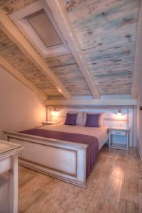 ein Schlafzimmer mit einem Bett und einer Holzdecke in der Unterkunft Piazza Apartments 1 in Petrovac na Moru