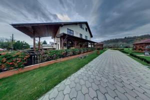 a cobblestone path in front of a building at Pensiunea Cabana Soimul in Comăneşti