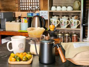 a table with a coffee pot and a plate of fruit at 행궁동-House1 in Suwon