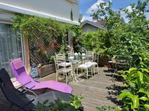 un patio con mesa y sillas en una terraza en Appart d'Hôtes Brive, en Brive-la-Gaillarde
