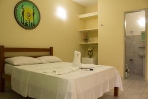 a bedroom with a bed and a clock on the wall at Pousada Maturi - Pipa in Pipa