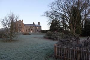 una casa vieja con una valla delante de ella en Newton Farmhouse B & B, en Jedburgh