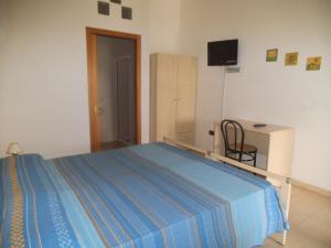 a bedroom with a blue bed and a tv at Agriturismo L'Agrumeto in Otranto