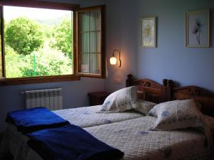sypialnia z dwoma łóżkami i dużym oknem w obiekcie Apartamentos Rurales Casa Tata w mieście Villaviciosa