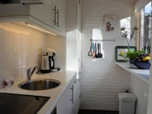 a kitchen with a sink and a counter top at Bungalow in Noordwijkerhout near Lake in Noordwijkerhout