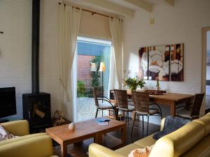 a living room with a fireplace and a table and chairs at Bungalow in Noordwijkerhout near Lake in Noordwijkerhout