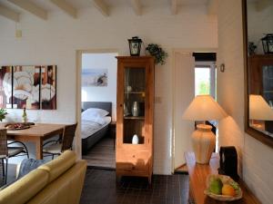 a living room with a couch and a table at Bungalow in Noordwijkerhout near Lake in Noordwijkerhout