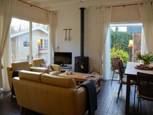 a living room with a couch and a fireplace at Bungalow in Noordwijkerhout near Lake in Noordwijkerhout +32 photos