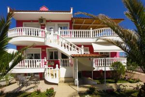 a house with a white and red facade at Nereids Apartments and Studios in Chrysi Ammoudia