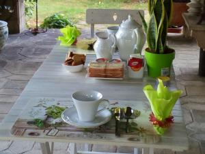 a table with tea cups and vases on it at B&B Luce Riflessa in Perugia