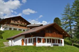 une grande maison au sommet d'une colline dans l'établissement Apartment Dolomit DG - GRIWA RENT AG, à Grindelwald