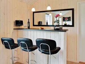 a bar with four black chairs and a mirror at 5 star holiday home in Kappeln in Kappeln