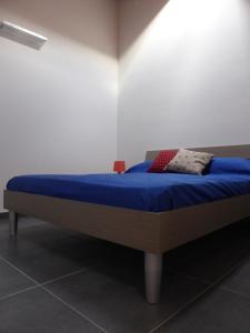 パレルモにあるAppartamento in Palazzo Lampedusaの青い毛布が付いた部屋のベッド1台分です。