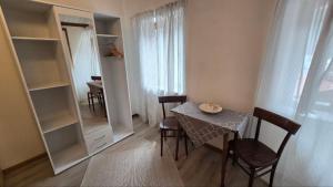 a dining room with a table and chairs and a mirror at Migana home in Auronzo di Cadore