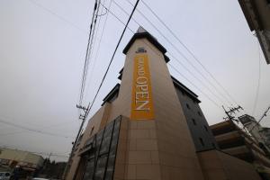 a building with a yellow sign on the side of it at Avenue Hotel in Jeonju