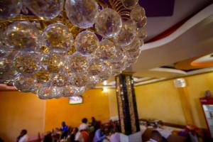 a large chandelier in a room filled with people at Grande Hotel in Isiolo