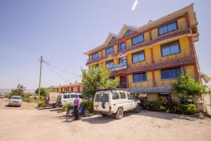 un edificio con un coche aparcado delante de él en Grande Hotel en Isiolo