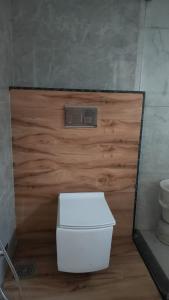 a toilet in a bathroom with a wooden door at Sai Dhara Resort in Kasrāwad