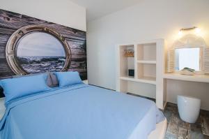 a bedroom with a large bed and a mirror at Blue Dream - Santorini in Kamari