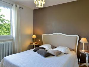 1 dormitorio con 1 cama blanca y 2 almohadas en Appart d'Hôtes Brive, en Brive-la-Gaillarde