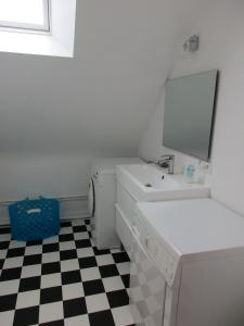 een badkamer met een wastafel en een wasmachine bij Gwenhadu in Paimpol
