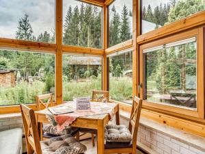 a dining room with a table and chairs and windows at Peaceful Stay in Jägersgrün in Bad Reiboldsgrün