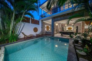 a swimming pool in front of a house at Luxury 3-Bedroom Pool Villa in Canggu Near Beach & Nightlife in Canggu