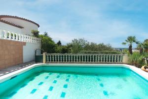 a swimming pool in front of a house at WELCS APARTAMENTO 282 EMP en villa con piscina compartida in Roses
