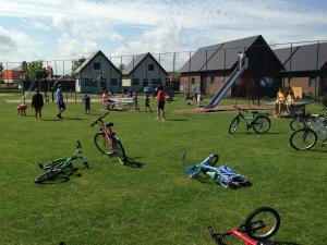 een groep mensen die spelen in een park met fietsen op het gras bij Camping Ter Hoeve in Bredene
