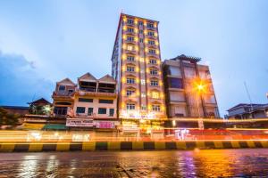 un edificio alto con luces delante en Good Luck Day Hotel & Apartment, en Phnom Penh
