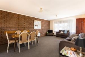 a living room with a couch and a table and chairs at Mildura Holiday Apartments in Mildura