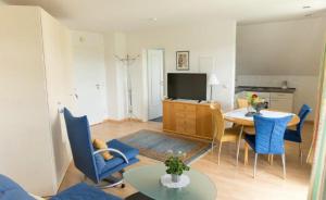 a living room with a table and blue chairs at ausZEIT - Ihr Sibyllenbad Gästehaus in Neualbenreuth