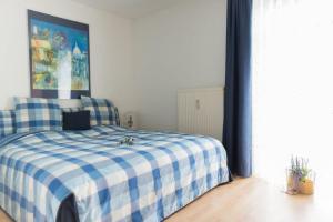 a bedroom with a bed with a blue and white checkered blanket at ausZEIT - Ihr Sibyllenbad Gästehaus in Neualbenreuth