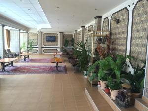 un hall avec de nombreuses plantes, tables et chaises dans l'établissement Olymp Hotel, à Sunny Beach
